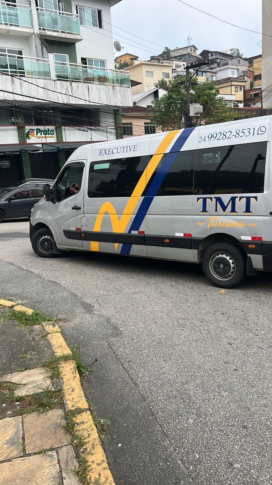 Van executiva da TMT Turismo com a identidade visual da empresa